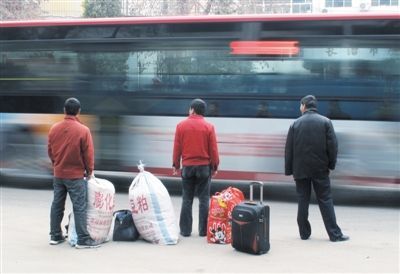11月15日，山西长治市城西路，几位农民工在路边等车。作为外来务工人员，他们在企业中很难享受完备的社会保障。资料图片